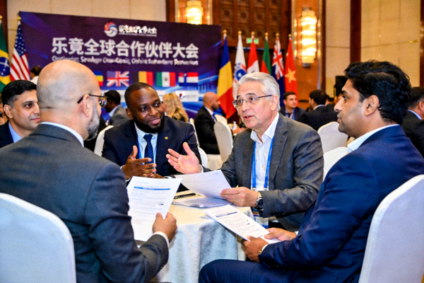乐竟全球合作伙伴大会现场，来自不同国家的企业代表正在交流洽谈的合作场景照片